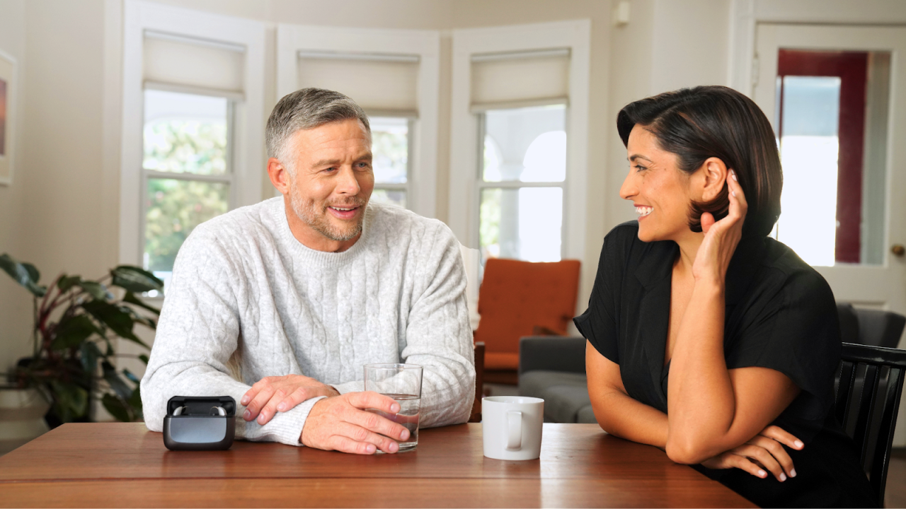 Two people talking at table.