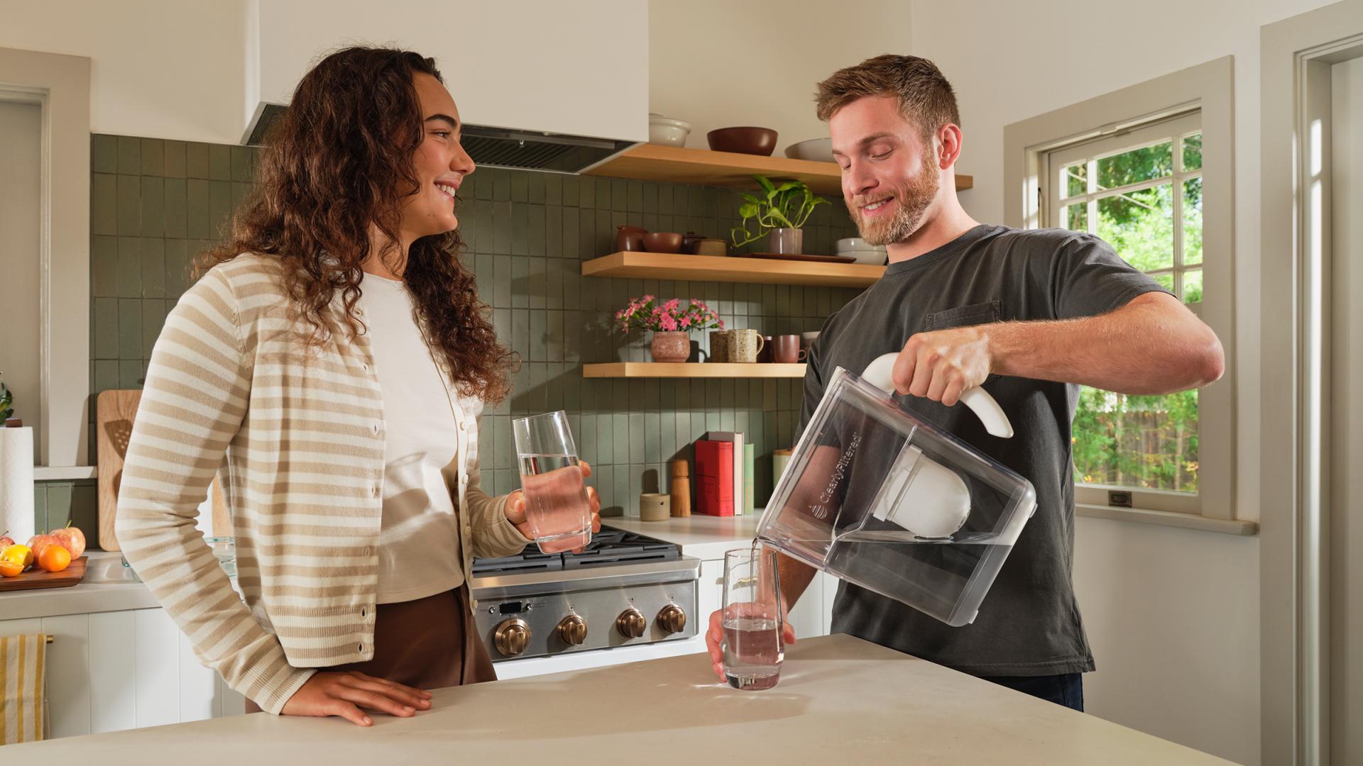 Man and woman pouring water into a glass