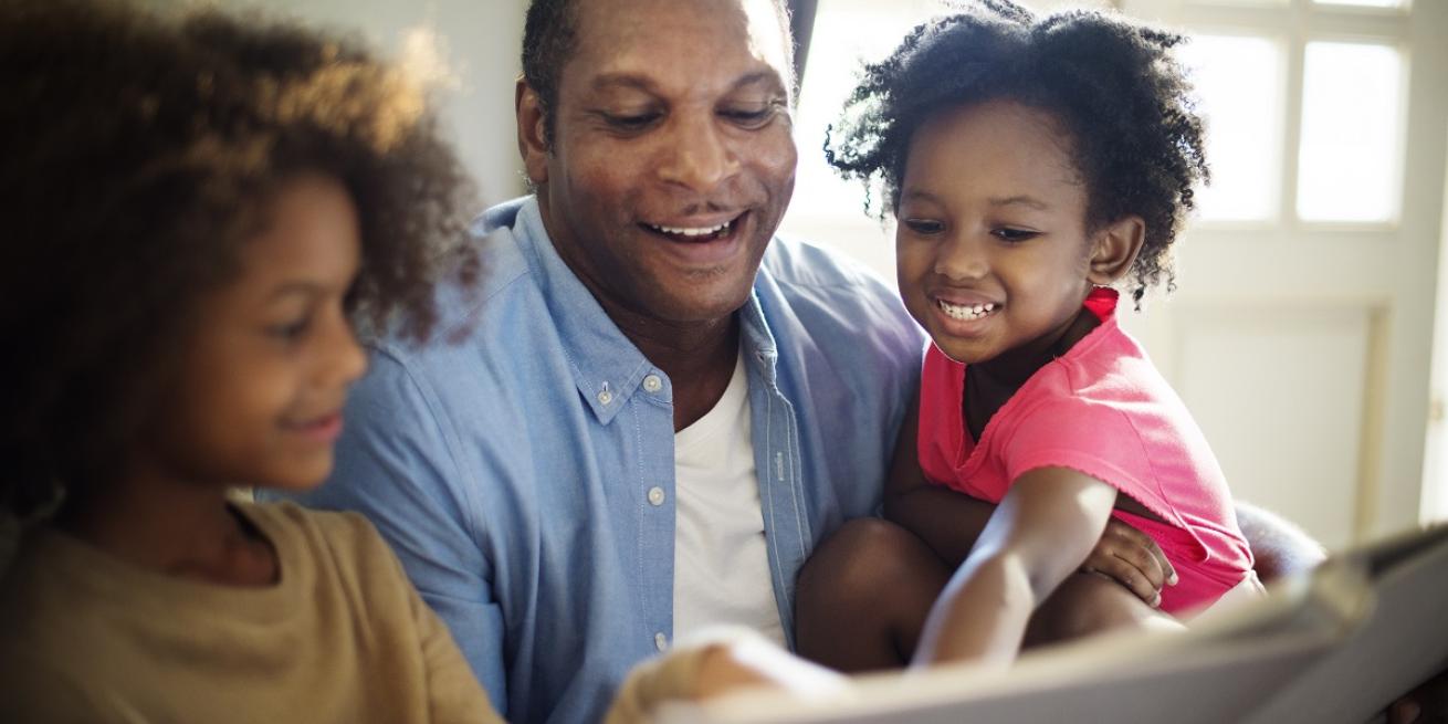 man reading to daughters